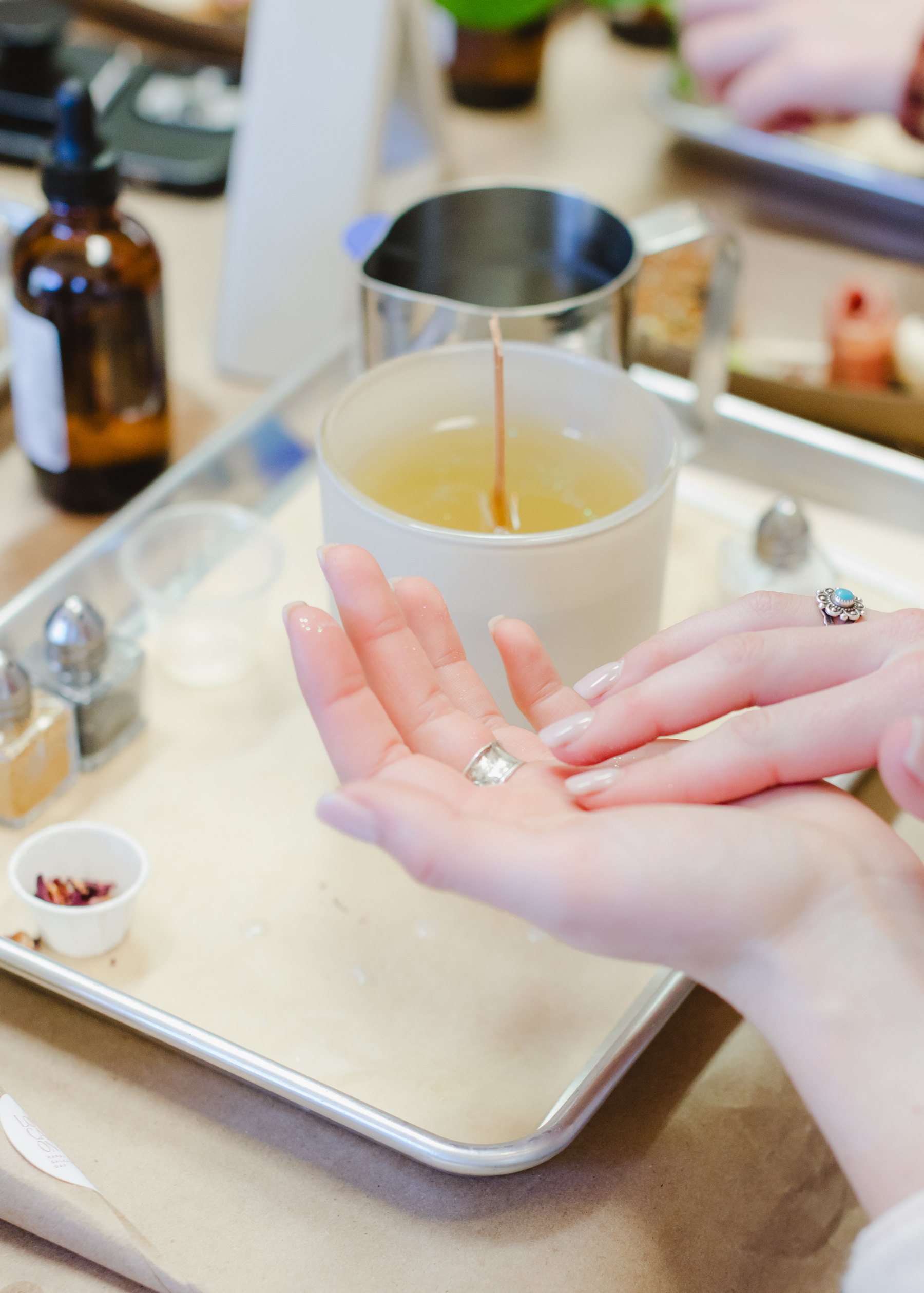 Hands working with fragrance materials at the studio bench